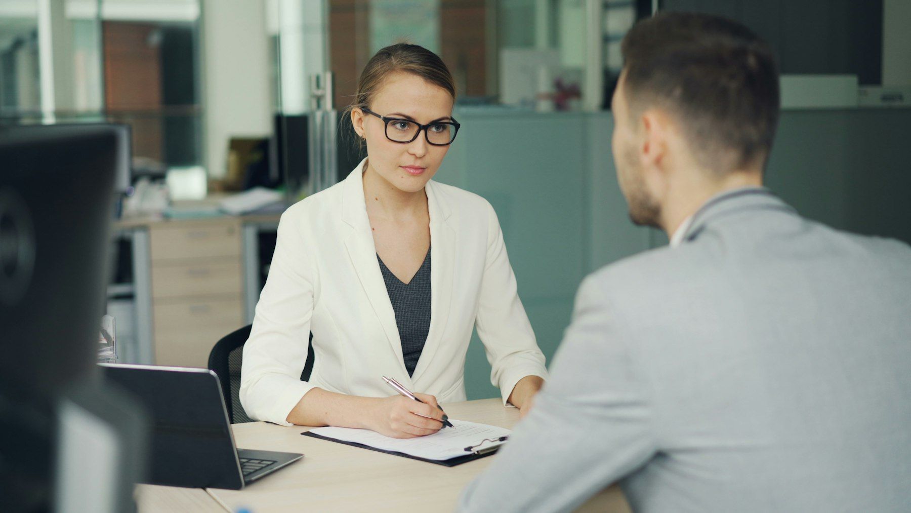 Hiring manager interviewing a candidate across an office desk