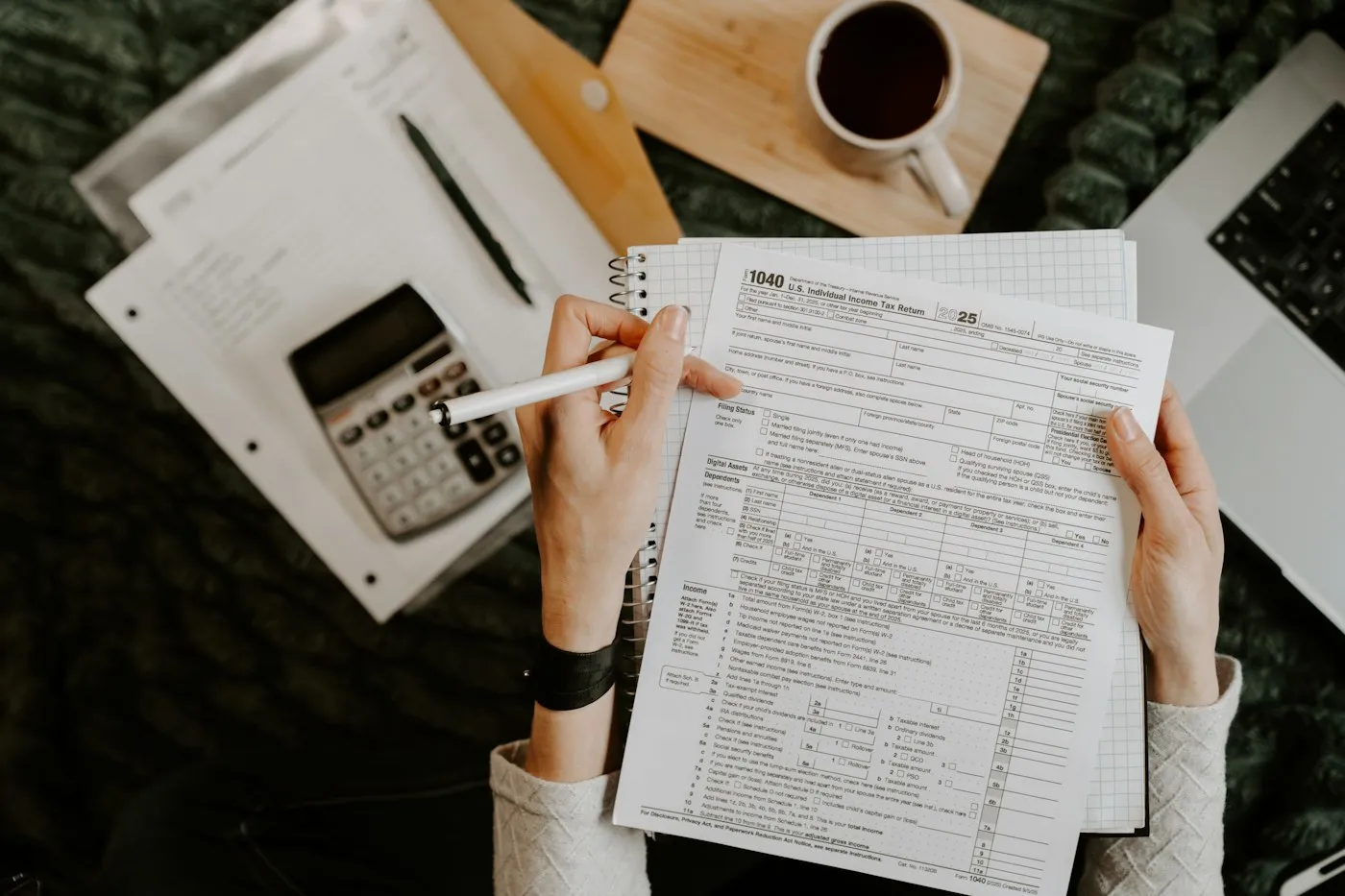 Calculator, laptop and financial documents on a desk